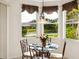 Bright breakfast nook featuring a glass table and views of the backyard pond at 2439 Sonoma W Dr, Nokomis, FL 34275