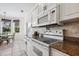Well-equipped kitchen with white appliances, granite countertops, and a cozy breakfast area with a backyard view at 2439 Sonoma W Dr, Nokomis, FL 34275