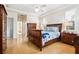 Bright main bedroom with tray ceiling, hardwood floors, and ensuite bathroom at 2439 Sonoma W Dr, Nokomis, FL 34275