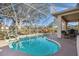 Sparkling screened-in pool has lounge chairs, tables, and chairs for outdoor living and entertaining at 2439 Sonoma W Dr, Nokomis, FL 34275