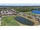 An aerial view showcases a golf course with pond, clubhouse, and surrounding community offering recreation and scenic beauty at 259 Golden Harbour Trl, Bradenton, FL 34212