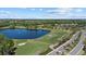 Scenic aerial view featuring a lush golf course with a tranquil lake, complementing the homes in a vibrant community at 259 Golden Harbour Trl, Bradenton, FL 34212