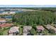 An aerial shot showcases the home's location near a scenic lake, surrounded by lush trees and a well-maintained landscape at 259 Golden Harbour Trl, Bradenton, FL 34212