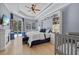 Light-filled bedroom with tray ceiling and view of screened pool and patio at 259 Golden Harbour Trl, Bradenton, FL 34212