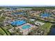 Aerial view of community pool, hot tub, and common areas surrounded by ponds and tropical landscaping at 259 Golden Harbour Trl, Bradenton, FL 34212