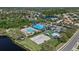Aerial view of the community pool, sand volleyball court, and common areas with lush tropical landscaping at 259 Golden Harbour Trl, Bradenton, FL 34212