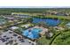 Aerial view of the community pool, hot tub, playground, and common areas surrounded by lush tropical landscaping at 259 Golden Harbour Trl, Bradenton, FL 34212