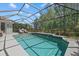 Inviting screened-in pool with waterfall feature, lush landscaping, and ample space for outdoor relaxation and entertaining at 259 Golden Harbour Trl, Bradenton, FL 34212