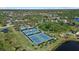 Aerial view of the tennis courts in this community featuring ponds, lush landscaping, and walking trails at 259 Golden Harbour Trl, Bradenton, FL 34212