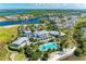 Aerial view featuring the clubhouse with pool, bay access, and surrounding waterfront community at 282 Sapphire Lake Drive Dr # 201, Bradenton, FL 34209