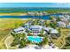 Expansive aerial view of the clubhouse, pool, waterfront homes, and picturesque bay at 282 Sapphire Lake Drive Dr # 201, Bradenton, FL 34209