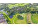 Aerial view of a golf course community with mature trees, manicured greens, and ponds throughout at 3153 Founders Club Dr, Sarasota, FL 34240