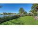 Well-manicured backyard with mature trees and plantings offers serene lake views at 3153 Founders Club Dr, Sarasota, FL 34240