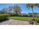 Lush backyard with a well-manicured lawn, mature trees, and colorful flower beds offers serene lake views at 3153 Founders Club Dr, Sarasota, FL 34240