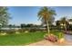 A perfectly maintained backyard with mature trees and plantings offers serene lake views at 3153 Founders Club Dr, Sarasota, FL 34240