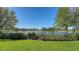 A well-maintained backyard is fenced and bordered by a lake and lush landscaping at 3153 Founders Club Dr, Sarasota, FL 34240