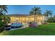 Relax in this backyard oasis, featuring a pool, spa, summer kitchen, beautiful landscaping, and a lounge area at 3153 Founders Club Dr, Sarasota, FL 34240