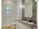 Elegant half bathroom featuring granite countertops, leaf patterned wallpaper, and shuttered window at 3153 Founders Club Dr, Sarasota, FL 34240