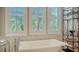 Bright bathroom featuring a large standalone tub next to a window and decorative shelf at 3153 Founders Club Dr, Sarasota, FL 34240