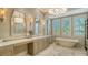 Luxurious bathroom featuring a soaking tub, double vanity, and large windows with plantation shutters at 3153 Founders Club Dr, Sarasota, FL 34240