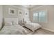 Bright bedroom with two beds, featuring neutral decor, a window with shutters, and modern furniture at 3153 Founders Club Dr, Sarasota, FL 34240