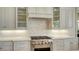 Detailed shot of the kitchen backsplash, stainless steel range, and custom cabinetry at 3153 Founders Club Dr, Sarasota, FL 34240
