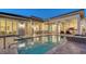 A beautiful in-ground pool with travertine deck is surrounded by an outdoor living space, summer kitchen, and spa at 3153 Founders Club Dr, Sarasota, FL 34240