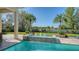 Luxury pool with a waterfall, surrounded by lush landscaping and manicured greenery at 3153 Founders Club Dr, Sarasota, FL 34240