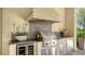 Built-in summer kitchen with stainless steel grill, granite countertops, and wine cooler at 3153 Founders Club Dr, Sarasota, FL 34240