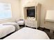 Cozy bedroom featuring two beds, a television cabinet, and a comfortable armchair at 3719 Lake Bayshore Dr # H-204, Bradenton, FL 34205