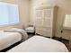 Relaxing bedroom featuring two beds, wicker furniture, and neutral tones at 3719 Lake Bayshore Dr # H-204, Bradenton, FL 34205