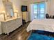 Bright bedroom with wicker furniture, balcony, and white bed at 3719 Lake Bayshore Dr # H-204, Bradenton, FL 34205