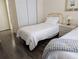 Bright bedroom with twin beds, stylish nightstand, and ample closet space, creating a cozy atmosphere at 3719 Lake Bayshore Dr # H-204, Bradenton, FL 34205