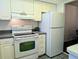 Well-lit kitchen features white appliances, ample cabinet space, and functional layout for daily cooking needs at 3719 Lake Bayshore Dr # H-204, Bradenton, FL 34205