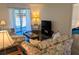 Cozy living room featuring floral sofas, dark wood floors, and access to an outdoor balcony at 3719 Lake Bayshore Dr # H-204, Bradenton, FL 34205