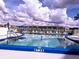 Inviting swimming pool with clear blue water, surrounded by lounge chairs and umbrellas for relaxation at 3719 Lake Bayshore Dr # H-204, Bradenton, FL 34205