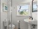 Bright bathroom featuring a toilet, a sink, and a shower stall at 4002 6Th Ave, Holmes Beach, FL 34217
