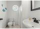 Well-lit bathroom features a decorative window and a classic pedestal sink, creating a clean and charming space at 4002 6Th Ave, Holmes Beach, FL 34217