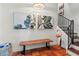 Elegant foyer featuring terracotta tile flooring, a wooden bench, tropical artwork, and a staircase at 4002 6Th Ave, Holmes Beach, FL 34217