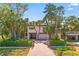 Charming two-story home with tropical landscaping and a brick-paved driveway leading to a two-car garage at 4002 6Th Ave, Holmes Beach, FL 34217
