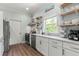 Bright kitchen features stainless steel appliances, white cabinets, and floating wood shelves at 4002 6Th Ave, Holmes Beach, FL 34217