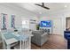 Open-concept living and dining area with coastal decor, a TV, and lots of natural light at 4002 6Th Ave, Holmes Beach, FL 34217