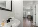 Bright powder room featuring a pedestal sink and a glimpse into the living area with beach-themed decor at 4002 6Th Ave, Holmes Beach, FL 34217