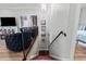 View of a wooden staircase with black wrought iron railing and a glimpse into the living spaces at 4002 6Th Ave, Holmes Beach, FL 34217