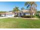 Charming single-story home featuring a well-manicured lawn, lush landscaping, and a welcoming blue front door at 4025 Giannini Ln, Sarasota, FL 34233