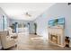 Bright living area features wood-style floors, a fireplace, and a sliding glass door, with a ceiling fan for added comfort at 411 28Th W St, Palmetto, FL 34221