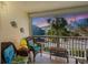 Cozy screened balcony with wicker furniture and bright throw pillows with a neighborhood view at 4307 Gulf Dr # 202, Holmes Beach, FL 34217