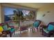 Comfortable screened balcony with wicker chairs, wooden flooring and neighborhood views at 4307 Gulf Dr # 202, Holmes Beach, FL 34217