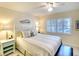 Comfortable bedroom with white furniture, plantation shutters and coastal decor at 4307 Gulf Dr # 202, Holmes Beach, FL 34217