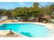 Bright blue community pool with nearby stone grill, tables, and shaded seating area at 4307 Gulf Dr # 202, Holmes Beach, FL 34217